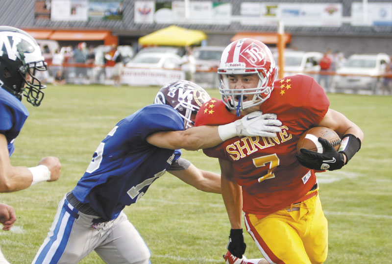 BREAKING FREE: Cony High School graduate Chandler Shostak, right, breaks away from Noble’s Ethan Beaulier to score a touchdown for the East in the first half of the Maine Shrine Lobster Classic on Saturday at Waterhouse Field in Biddeford. Shostak had five receptions for 155 yards in the East’s 25-13 victory.