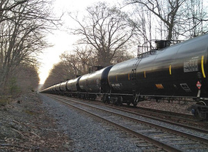 A Pan Am Railways freight train moves through the Riverton neighborhood of Portland, bearing a red placard that indicates it is carrying crude oil. A federal hearing Wednesday was intended to give interest groups and the public a chance to comment generally on the transportation of hazardous materials via rail.