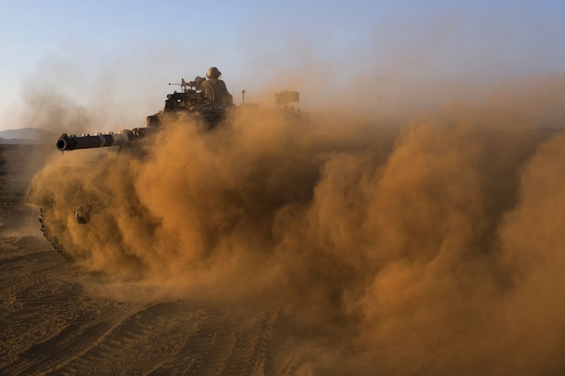 Israeli soldiers drive a tank at a staging area in the Golan Heights, near the border between the Israeli-controlled Golan Heights and Syria, Thursday, Aug. 29, 2013. United Nations experts are investigating the alleged use of chemical weapons in Syria as the United States and allies prepare for the possibility of a punitive strike against Syrian President Bashar Assad's regime, blamed by the Syrian opposition for the attack. The international aid group Doctors Without Borders says at least 355 people were killed in the Aug. 21 attack. (AP Photo/Bernat Armangue)