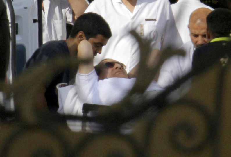 Medics escort former Egyptian President Hosni Mubarak, 85, into an ambulance after he was flown by a helicopter ambulance to the Maadi Military Hospital from Tora prison in Cairo on Thursday.
