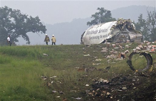 Fire crews investigate where a UPS cargo plane lies on a hill at Birmingham-Shuttlesworth International Airport after crashing on approach Wednesday in Birmingham, Ala.