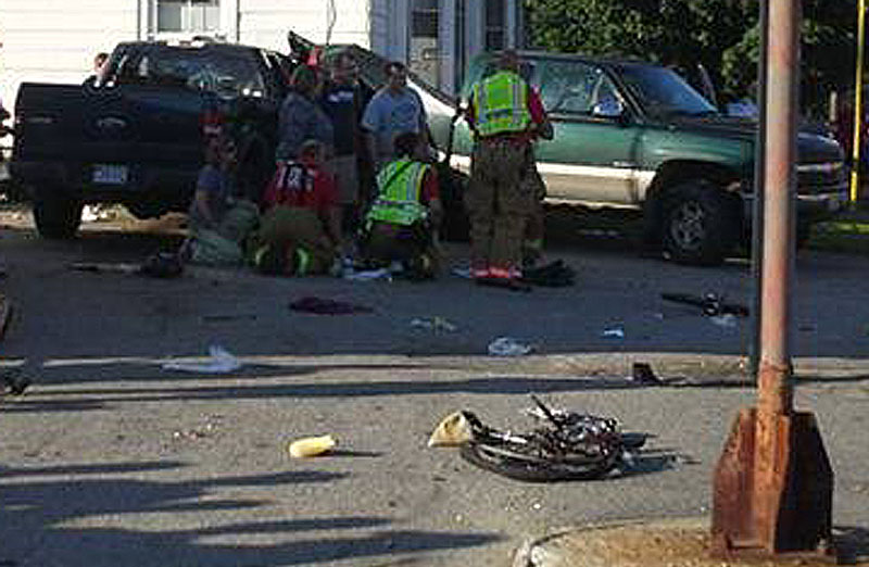 Rescuers attend to one of the victims at the scene of the crash in Biddeford last week. The driver who allegedly struck a family of cyclists has been charged.