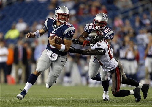 New England Patriots quarterback Tim Tebow runs past Tampa Bay Buccaneers defensive back Michael Adams as he's blocked by Patriots wide receiver Josh Boyce in a preseason game on Aug. 16, 2013, in Foxborough, Mass.