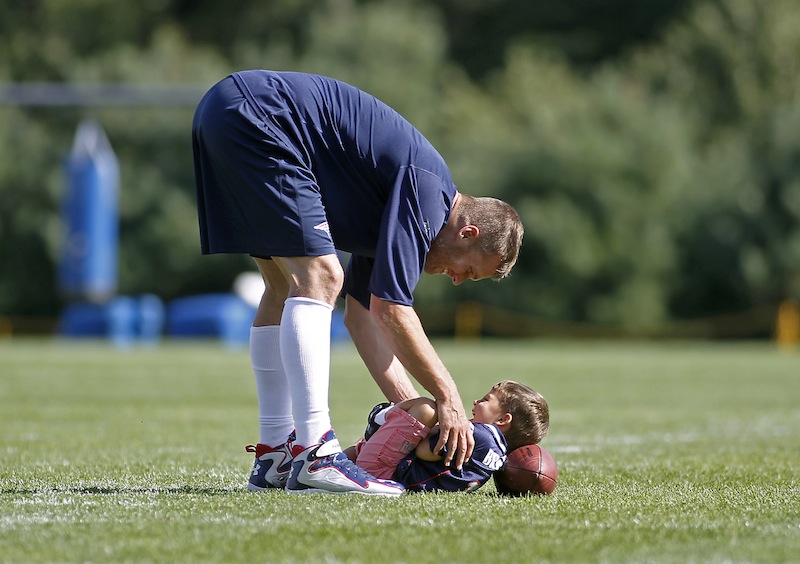 New England Patriots quarterback Tom Brady plays with his son Benjamin Thursday following the Patriots' joint workout with the Tampa Bay Buccaneers at NFL football training camp in Foxborough, Mass.