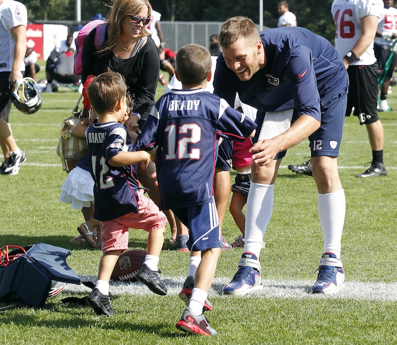 Tom Brady waits as his sons, John Moynahan, center, and Benjamin Brady, left, run to him following the Patriots' joint workout with the Tampa Bay Buccaneers on Thursday.