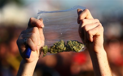 A participant holds up a bag of marijuana during the first day of the 2011 Hempfest at Myrtle Edwards Park in Seattle. Tens of thousands are expected to attend Hempfest this weekend, even though marijuana is newly legal in Washington state.