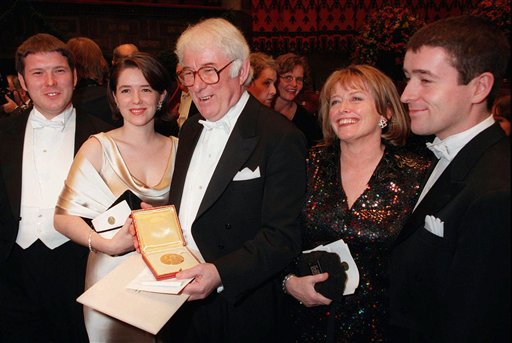 This 1995 photo shows Irish poet Seamus Heaney, center, displaying his Nobel literature prize medal, surrounded by his family.