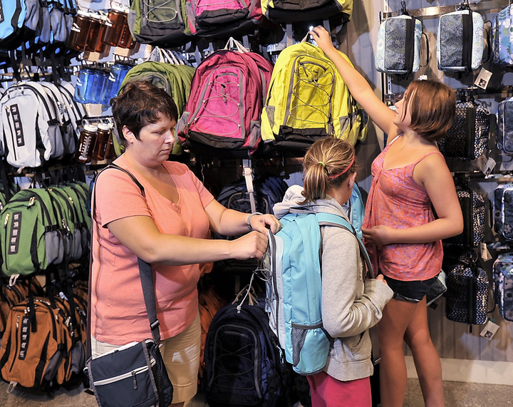 Surrounded by a wall of backpacks at L.L. Bean on Tuesday, Leanne MacKay helps her daughters, Maggie, 13, and Emily, 10, find the right one for their school books. They are from Halifax, Nova Scotia, and said they mixed vacation with buying back-to-school clothes and supplies they could only find in Freeport. They planned on visiting other stores in the popular shopping town as well, according to MacKay.