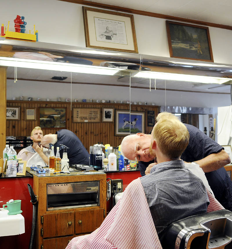 Gil Taylor gets his beard trimmed Thursday from barber Roland Marquis at Dom's Barbershop in Hallowell.