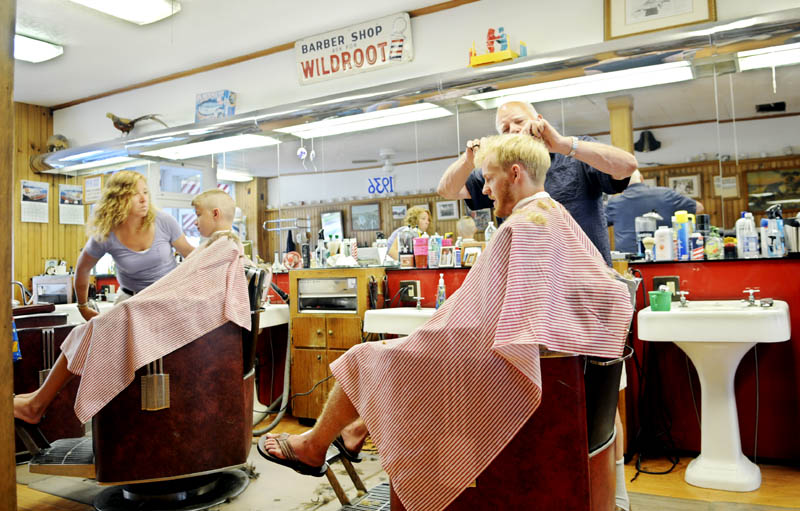 Gil Taylor, right, and Cole Allen get trims Thursday at Dom's Barber Shop in Hallowell from barbers Julie Keithley and Roland Marquis.