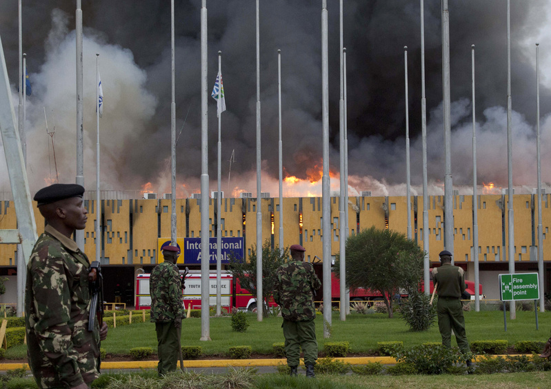Police stand guard as fire engulfs the international arrivals area of Jomo Kenyatta International Airport in Nairobi, Kenya, on Wednesday.