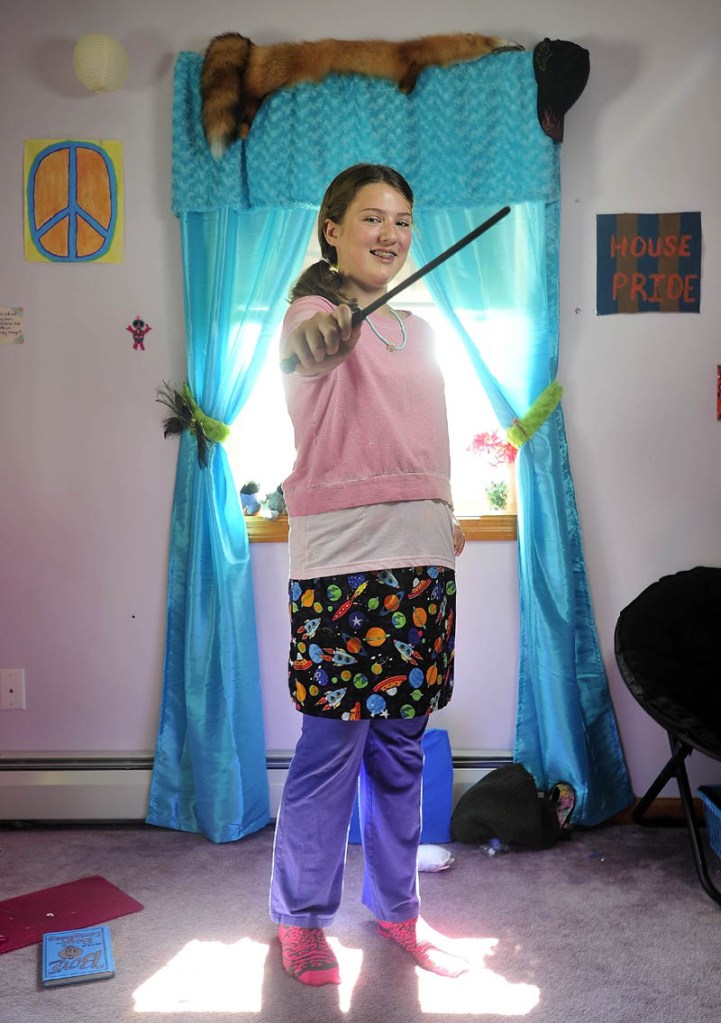 Bryn Mayo, waves her wand as she stands in her Fairfield home bedroom dressed as her favorite Harry Potter character, Luna, on Wednesday. Mayo plans to attend a Harry Potter party at the Lawrence Library in Fairfield on Thursday.