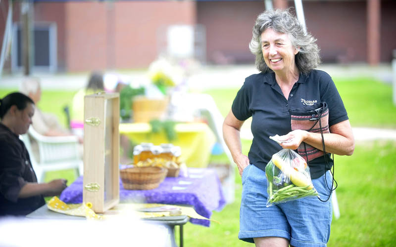 Ellen McQuiston, of Anson, shops at the Madison farmers market at a new park on Main Street today. The farmers market will be open on Sundays from 9 a.m. to 2 p.m. through Sept. 8.
