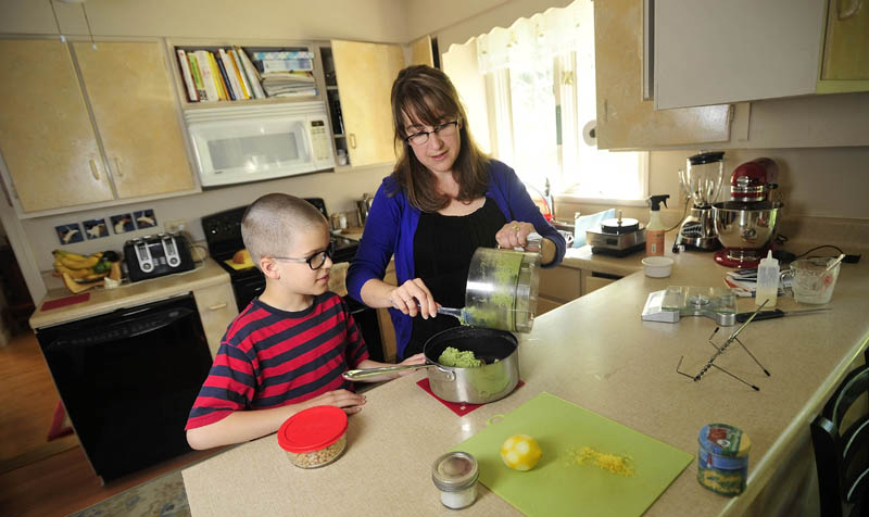 Noah Koch, 9, and his mother, Hilary, of Waterville, prepare his award-winning pesto in their Waterville home today. Noah was selected as a winner in First Lady Michelle Obama’s Healthy Lunchtime Challenge.