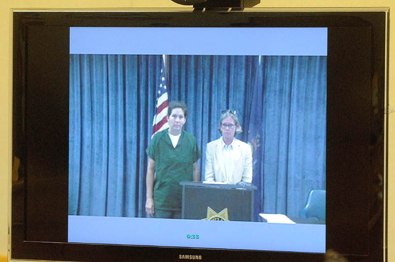 BethMarie Retamozzo, left, stands with Lisa Whittier, attorney representation for her arraignment via video conference with Judge Charles Dow. at the Waterville District Court on Wednesday.