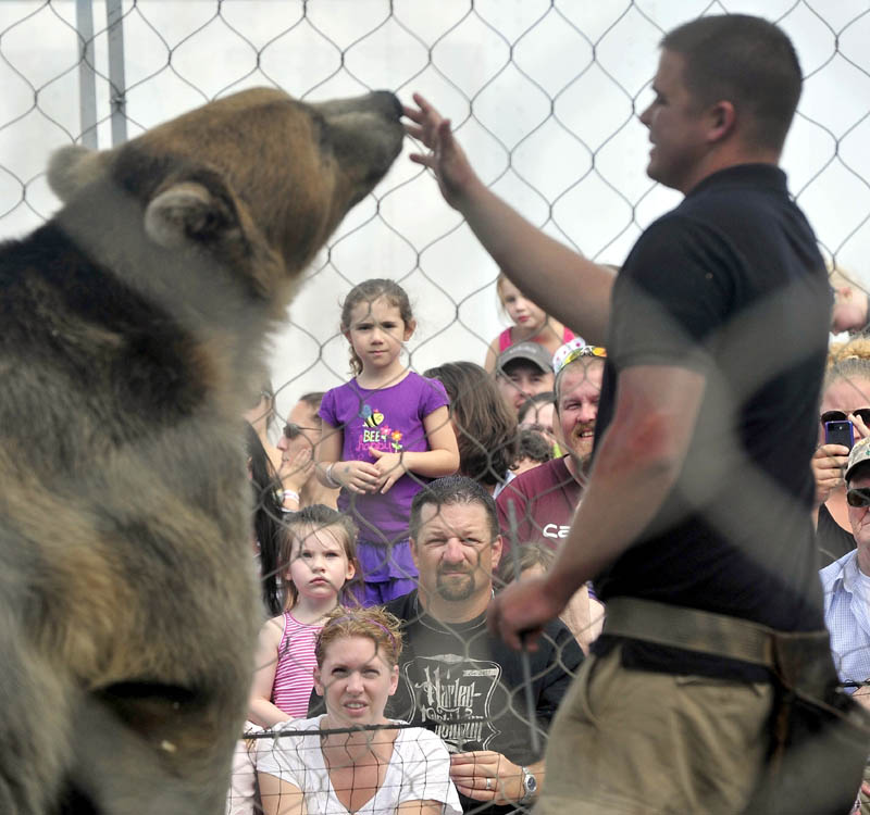 Dexter Osborn, owner of A Grizzly Experience, puts on a show with his grizzly bear, Tonk, at the Skowhegan State Fair today.