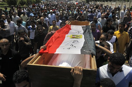 Supporters of Egypt's ousted President Mohammed Morsi march towards Old Cairo carrying the coffin, covered with a national flag, of a colleague who was killed during Wednesday's clashes.