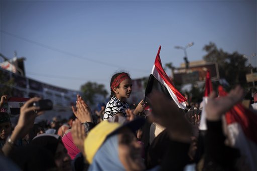 An Egyptian girl waves a national flag while supporters of Egypt's ousted President Mohammed Morsi chant slogans against the Egyptian Army at the sit-in at Rabaah al-Adawiya mosque, which is fortified with multiple walls of bricks, tires, metal barricades and sandbags, and where protesters have installed their camp in Nasr City, Cairo, Egypt, on Sunday.