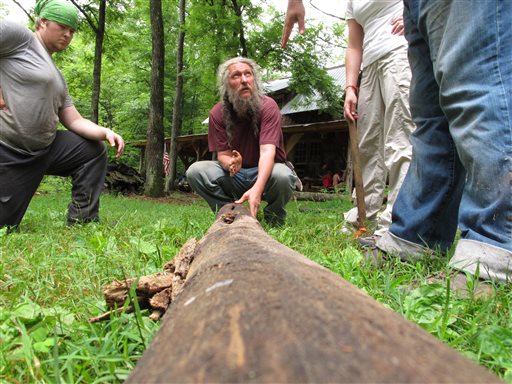 Eustace Conway, center, shows campers how to split a log at his Turtle Island Preserve in Triplett, N.C., on June 27. When Conway bought his first 107 acres in 1987, his vision for Turtle Island was as "a tiny bowl in the earth, intact and natural, surrounded by pavement and highways." People peering inside from nearby ridges would see "a pristine and green example of what the whole world once looked like."