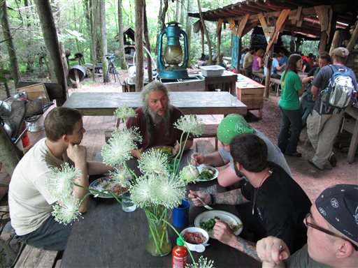 Naturalist Eustace Conway, center, speaks to diners at the Nacho Mama's eating hall at Turtle Island Preserve in Triplett, N.C., on June 27. People come from all over the world to learn natural living and how to go off-grid, but local officials ordered the place closed over health and safety concerns.