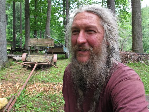 Eustace Conway sits near horse-drawn farm implements at his Turtle Island Preserve in Triplett, N.C., on June 27. People come from all over the world to learn natural living and how to go off-grid, but local officials ordered the place closed over health and safety concerns.