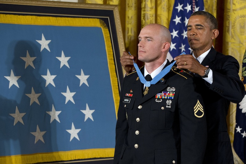 President Barack Obama awards US Army Staff Sgt. Ty M. Carter the Medal of Honor for conspicuous gallantry, Monday, Aug. 26, 2013, during a ceremony in the East Room of the White House in Washington. Carter received the medal for his courageous actions while serving as a cavalry scout with Bravo Troop, 3rd Squadron, 61st Cavalry Regiment, 4th Brigade Combat Team, 4th Infantry Division, during combat operations in Kamdesh District, Nuristan Province, Afghanistan on Oct. 3, 2009. Carter is the fifth living recipient to be awarded the Medal of Honor for actions in Iraq or Afghanistan. (AP Photo/Jacquelyn Martin)