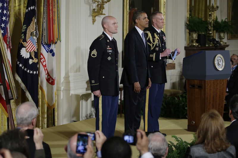 President Barack Obama stands with US Army Staff Sgt. Ty M. Carter as the citation is read as he awards him the Medal of Honor for conspicuous gallantry, Monday, Aug. 26, 2013, during a ceremony in the East Room of the White House in Washington. Carter received the medal for his courageous actions while serving as a cavalry scout with Bravo Troop, 3rd Squadron, 61st Cavalry Regiment, 4th Brigade Combat Team, 4th Infantry Division, during combat operations in Kamdesh District, Nuristan Province, Afghanistan on Oct. 3, 2009. Carter is the fifth living recipient to be awarded the Medal of Honor for actions in Iraq or Afghanistan. (AP Photo/Carolyn Kaster)