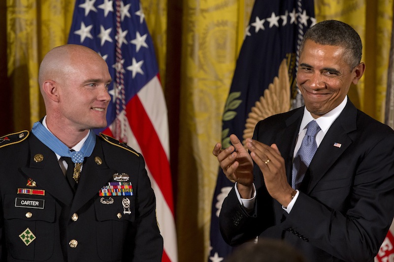 President Barack Obama applauds after awarding US Army Staff Sgt. Ty M. Carter, left, the Medal of Honor for conspicuous gallantry, Monday, Aug. 26, 2013, during a ceremony in the East Room of the White House in Washington. Carter received the medal for his courageous actions while serving as a cavalry scout with Bravo Troop, 3rd Squadron, 61st Cavalry Regiment, 4th Brigade Combat Team, 4th Infantry Division, during combat operations in Kamdesh District, Nuristan Province, Afghanistan on Oct. 3, 2009. Carter is the fifth living recipient to be awarded the Medal of Honor for actions in Iraq or Afghanistan. (AP Photo/Jacquelyn Martin)