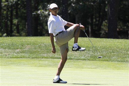 President Barack Obama reacts as he misses a shot while golfing on the first hole at Farm Neck Golf Club in Oak Bluffs, Mass., on the island of Martha's Vineyard, in this Aug. 11, 2013, photo.