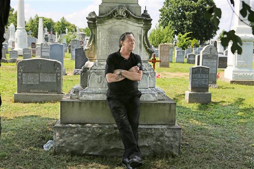 Patric Abedin, who also goes by the name "Nick Beef," poses for a photo among the grave markers at Calvary Cemetery in the Queens borough of New York on Aug. 2. In 1975, Abedin bought the grave plot next to where presidential assassin Lee Harvey Oswald is buried, and then placed the granite marker inscribed with "Nick Beef" there in 1997. For years, curiosity seekers visiting Oswald's Fort Worth, Texas, grave have wondered about the simple headstone next door.