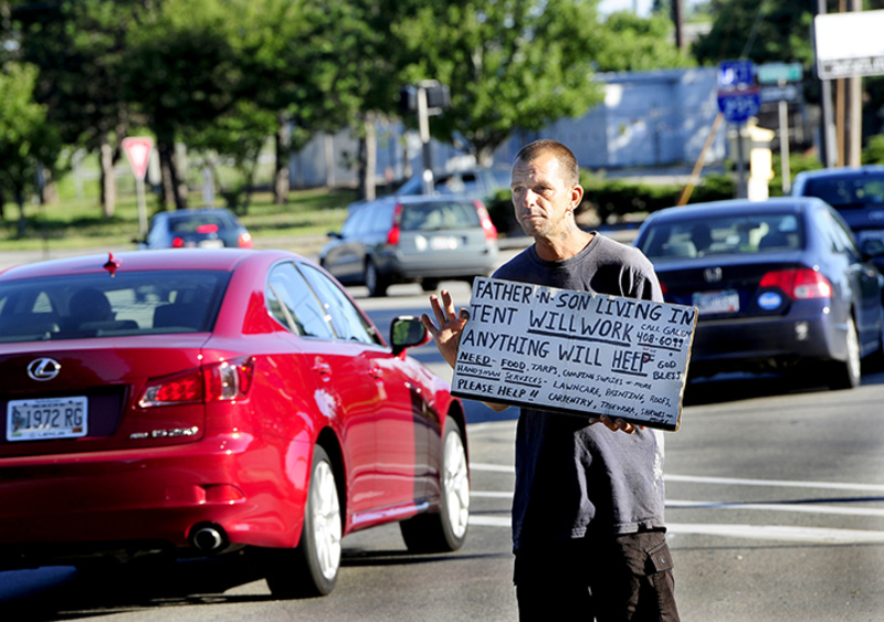 Galen Jordan panhandles – legally – at the corner of High Street and Forest Avenue in Portland early Thursday. Police were to begin enforcing a new ordinance Thursday that prohibits panhandling in roadway medians.
