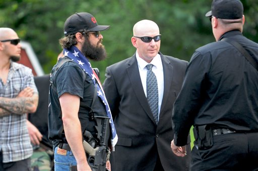 Gilberton Police Chief Mark Kessler, center, talks with members of the Constitutional Security Force outside Borough Hall in Gilberton, Pa., last month. Kessler says he expects to be fired for posting incendiary videos in which he rants obscenely about the Second Amendment and liberals while spraying machine-gun fire with borough-owned weapons.