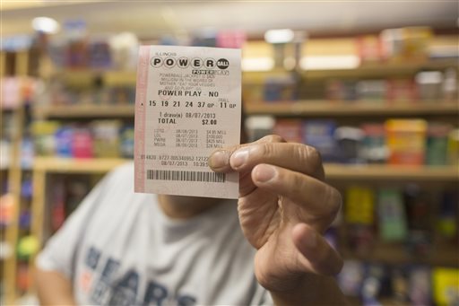 A man holds up his Powerball ticket inside of a convenience store in Chicago, Wednesday. Three tickets — one sold in Minnesota and two in New Jersey — matched Wednesday's winning numbers for a jackpot estimated at $448 million at the time of the drawing.