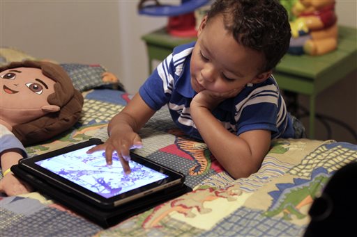 Frankie Thevenot, 3, plays with an iPad in his bedroom at his home in Metairie, La., in this October 2011 photo. The American Academy of Pediatrics discourages any electronic "screen time" for infants and toddlers under age 2, while older children should be limited to one to two hours a day.