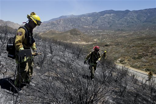 Firefighters look for hot spots as they walk through the scorched area on Friday near Banning, Calif. Southern California firefighters are facing another day of battle as they try to corral a wildfire that has destroyed 26 homes.