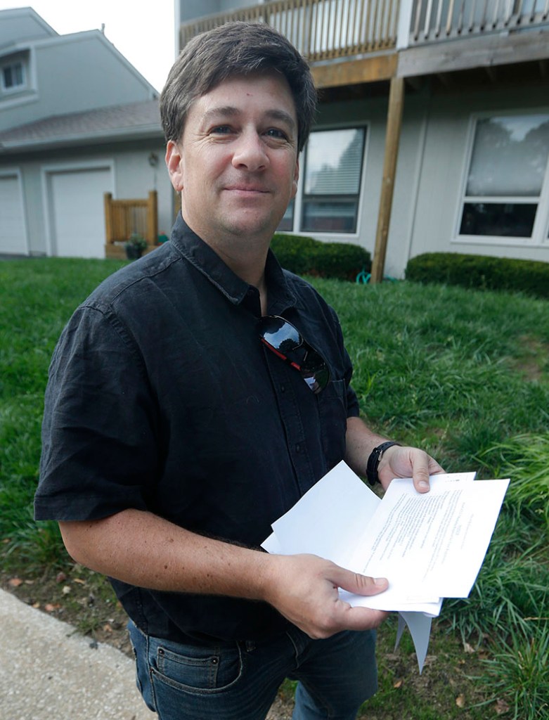 Aaron Belenky holds a letter from election officials while standing in front of his apartment in Overland Park, Kan., Wednesday, Aug. 14, 2013. Belenky allowed the American Civil Liberties Union to list him as one of three aggrieved voters in a notice sent this week to Kansas Secretary of State Kris Kobach.