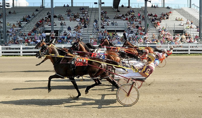 The pack passes the starting line in the Walter H. Hight Memorial Pace at the Skowhegan Fairgrounds on Saturday. Real Special won with a time of 1:54.1.