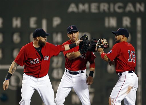Boston Red Sox outfielders Jonny Gomes, left, Jacoby Ellsbury and Shane Victorino (18) celebrate after defeating the Chicago White Sox 4-3 in a baseball game at Fenway Park in Boston, Friday, Aug. 30, 2013. (AP Photo/Elise Amendola)