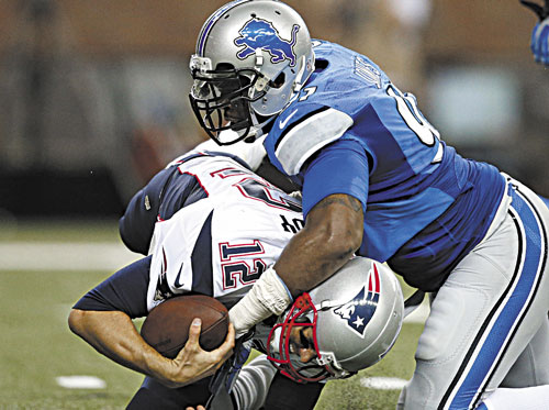 DOWN, BUT NOT OUT: New England Patriots quarterback Tom Brady (12) is sacked by Detroit Lions defensive end Jason Jones (91) in the second quarter of the Lions’ 40-9 win in a preseason game Thursday in Detroit.