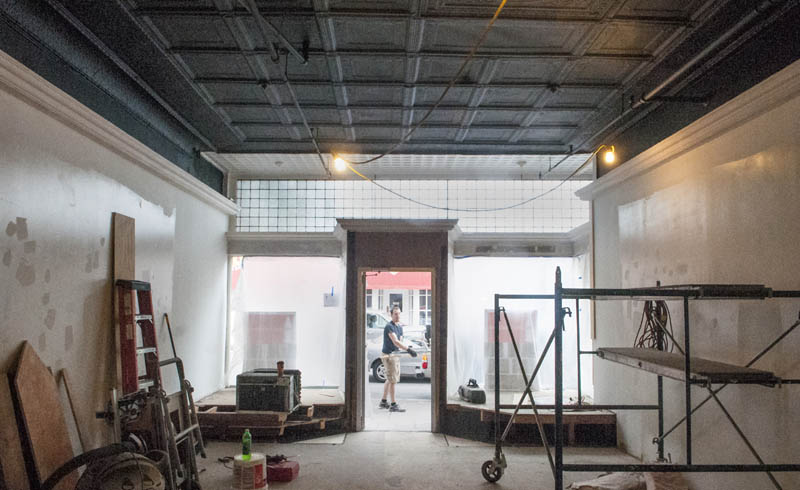 Ian Pillsbury is framed in the doorway during renovation work at the new location of LIsa's Legit Burritos, today on Water Street in downtown Augusta. As part of the renovation work the dropped tile ceiling was removed to expose the ornated metal ceiling and upper front windows.
