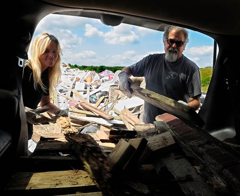 Maggie Peele, left, and Don Vellani throw scrap wood onto the large rubbish pile at Hatch Hill Landfill today in Augusta.