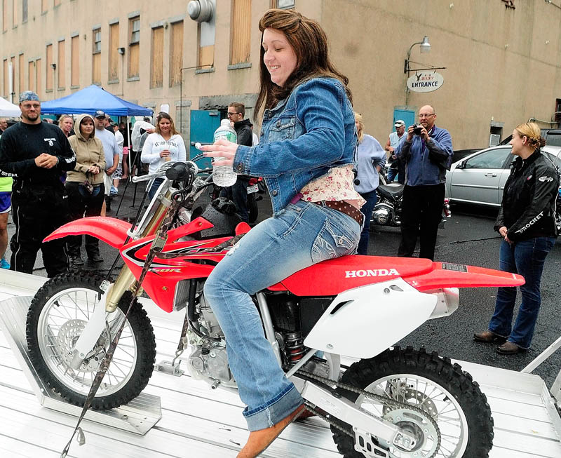 Kate McPherson, 17, of Litchfield, tries out the new Honda CRF 150 that she received during a Make-A-Wish Maine event on Saturday in the parking lot of the Fraternal Order of Eagles 3137 in Augusta.