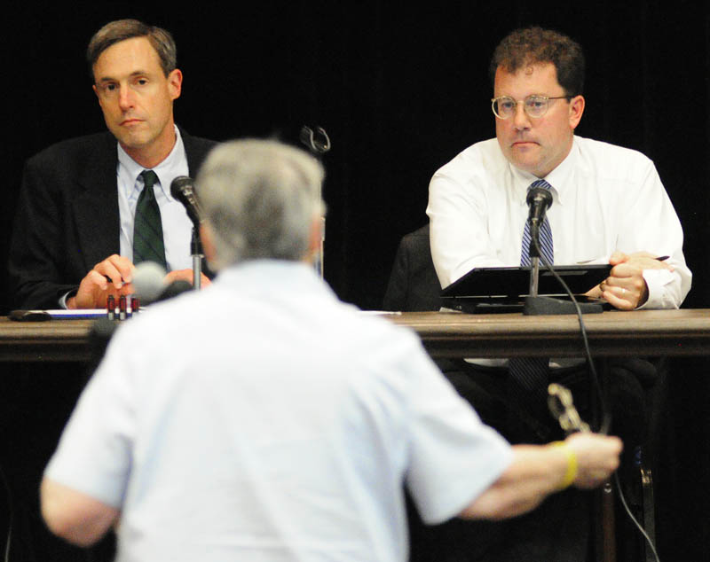 Public Utilities Commission members David Littell, left, and Mark Vannoy listen to Marguerite Lachance testify about smart meters during a hearing on Wednesday at Jewett Hall on the campus of University of Maine at Augusta.