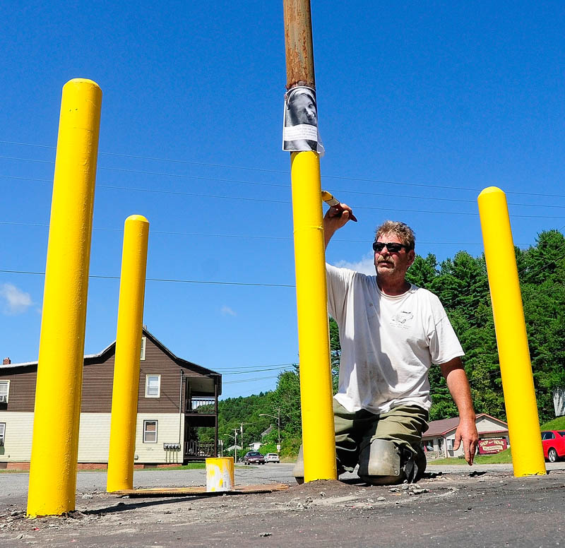 Bob Eldridge paints a sign post on Friday at College Carryout on Mount Vernon Avenue in Augusta. He said that he was going to paint the upper part black.