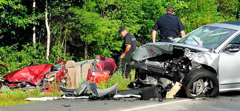 Kennebec County Sheriff's Department Sgt. Mike Pion, left, and Augusta Police Lt. Christopher Massey look over two of three cars involved in an accident today on the Route 3 connector, between Riverside Drive and North Belfast Avenue in Augusta.