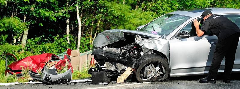 Kennebec County Sheriff's Department Sgt. Mike Pion, looks at one of the cars involved while beginning his reconstruction of an accident today on the Route 3 connector between Riverside Drive and North Belfast Avenue in Augusta.