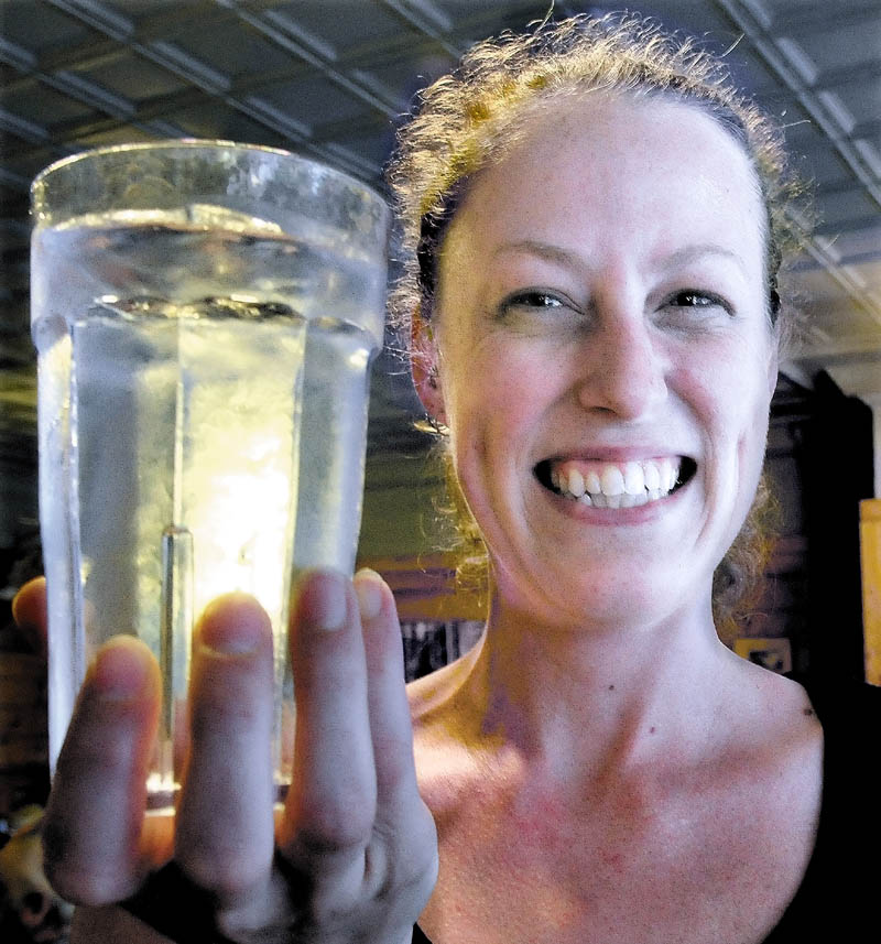 Amber Strickland holds a glass of water from the Bingham water supply at Thompson's Restaurant recently. Strickland said she has lived all over New England, and Bingham's water is the best tap water she has had. "We have never heard a complaint from customers," she said.