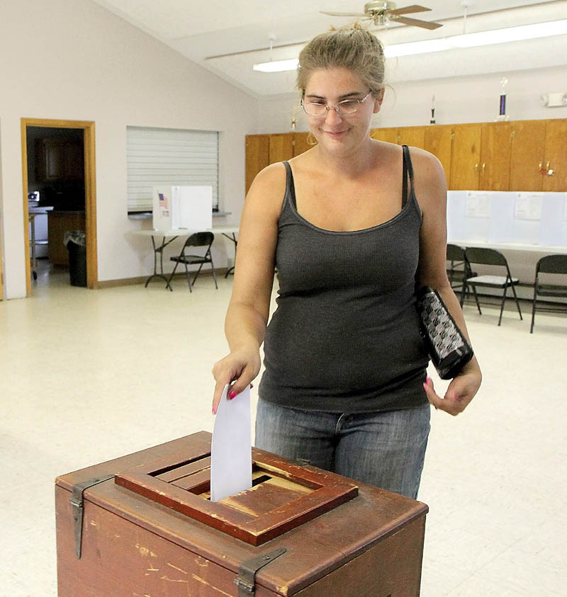Clinton resident Stacey Reed casts her vote on the town's police department budget today.