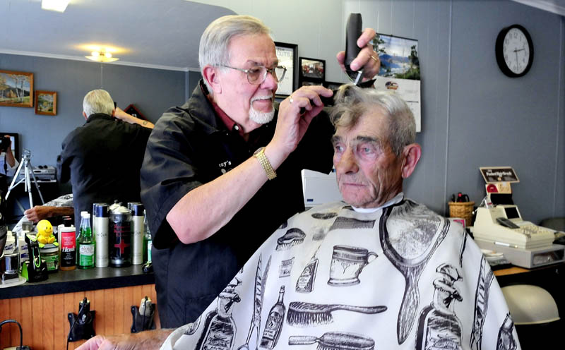 Freeman "Buzzy" Buzzell cuts the hair of customer Ron Frazier at his shop on Main Street in Madison recently. Buzzell said he has been a barber for nearly five decades and enjoys his customers and meeting new ones.
