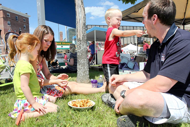 Liam Rose, 3, shares a French fry with his dad Phil while eating lunch with his sister Isabelle, 4, and mom Heather at the Taste of Greater Waterville on Wednesday.